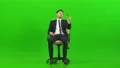 The man talking on the office chair on the green background 4k or 4k+ Resolution