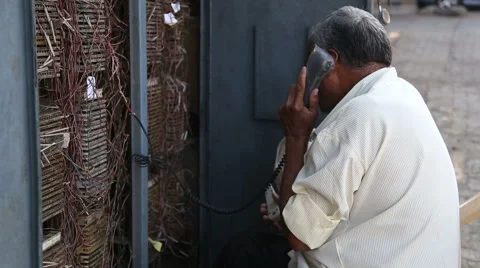 Man talking on an old-fashioned phone on the street of Mumbai. Stock Footage 49142387