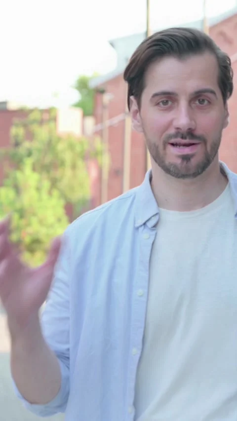 Man Talking on Online Video Call, while Walking in Street, Vertical Video Stock Footage 339665033