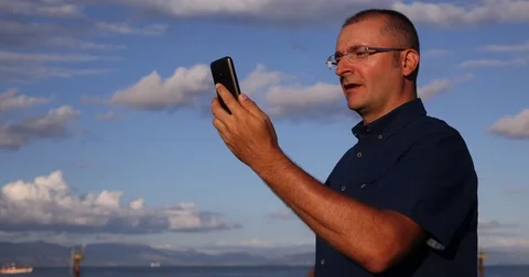 Man Talking Partner Video Conference on Mobile Phone Nature View Blue Sky Day Stock Footage 75846463