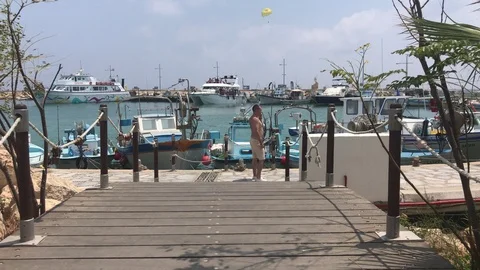 Man Talking on phone Against Small Boats in a Fishing Shelter Stock Footage 93336847