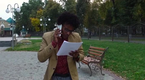 Man talking phone and looking documents on the street Stock Footage 68594654