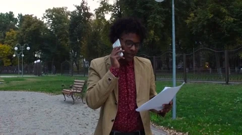 Man talking phone and looking documents on the street Stock Footage 68594823