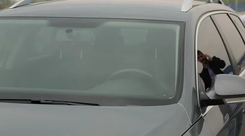 Man talking on the phone and sits in the car outside view Stock Footage 64587044