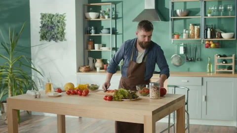 Man Talking by Phone and Use Laptop While Cooking Breakfast. Stock Footage 194610876