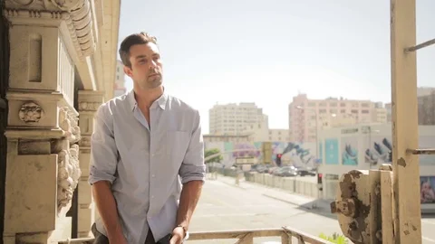 Man talking on phone on balcony Stock Footage 76734783