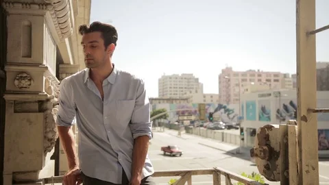 Man talking on phone on balcony 스톡 동영상 76734785