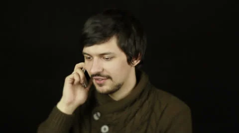 Man talking on the phone on a black background Stock Footage 22714537
