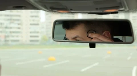 Man talking on the phone in the car mirror view Stock Footage 64587126