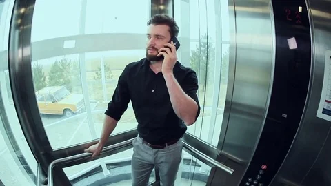 Man talking on the phone in the elevator Stock Footage 73469899