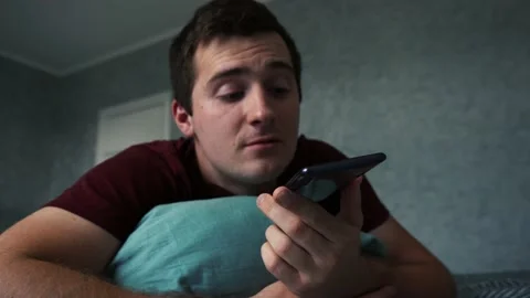 Man talking on the phone lying on the couch 스톡 동영상 166613469