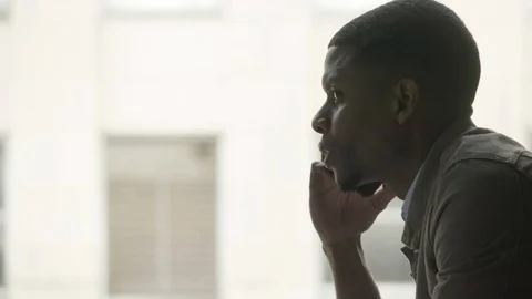 Man talking on the phone near the window Stock Footage 112053003