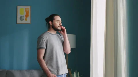 Man Is Talking on the Phone, Staring at Window Stock Footage 132432544