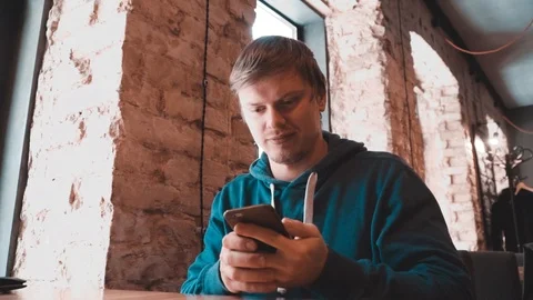The man is talking on the phone table in a cafe Stock Footage 87285686