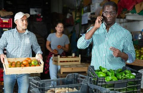 Man talking on phone in vegetable warehouse 库存照片