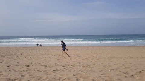 Man talking on the phone walking down the beach Stock Footage 103145825