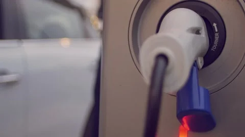 Man talking on the phone while charging its electric car Stock Footage 62226440