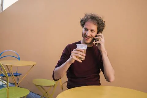 Man talking on the phone while drinking beer. Stock Photos