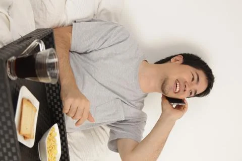 Man talking by phone while having breakfast Stock Photos