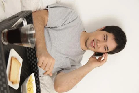 Man talking by phone while having breakfast Stock-Fotos