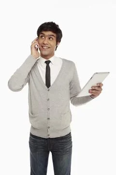 Man talking on the phone while looking at digital tablet Stock Photos