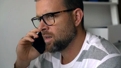 Man talking on the phone while using desktop computer Stock-Footage 127906462