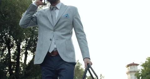 A man is talking on the phone while walking down a city street. Video stock 138587076