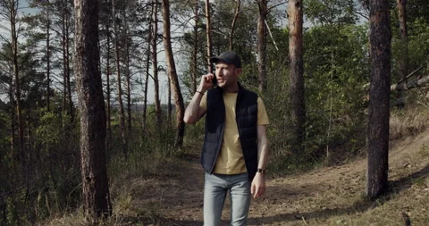 A man is talking on the phone while walking in the park Stock Footage 138640891