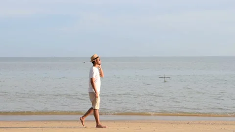 Man talking on the phone while walking on the beach Video stock 145186398