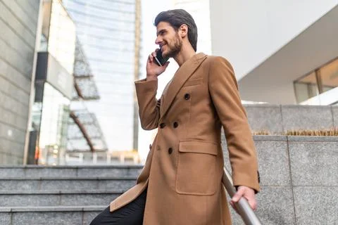 Man talking on the phone while walking down a stair Stock Photos
