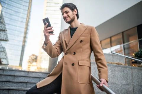 Man talking on the phone while walking down a stair 写真素材