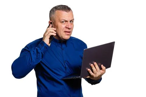 Man talking on phone while working on laptop Stock Photos