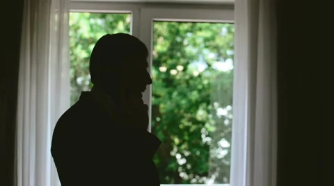 Man talking on the phone by the window . 動画素材 59731896