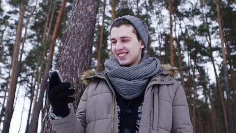 A man talking on the phone in the winter forest Stock Footage 70989674