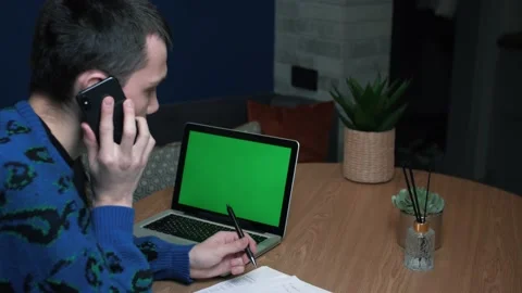 Man talking on the phone, work with papers, and looking on laptop Green Screen Stock Footage 144693083