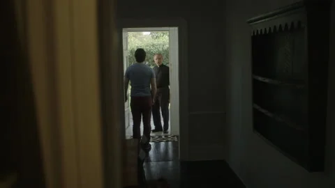 Man talking to priest at his front door about strange things happening at home Stock Footage 202903578
