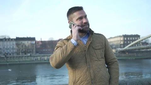 Man talking by smartphone on the background of the river, steadicam  库存影片 72775727