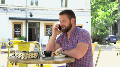 Man talking by smartphone during breakfast in cafe Vidéo 67626969