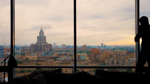 Man talking on the smartphone enters frame and exits near the panoramic window Stock Footage 103200210