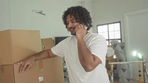 Man talking on smartphone with hand on stacked cardboard boxes, leaning and.. Stock Footage 337399188