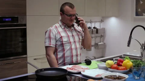 Man talking on a smartphone in the kitchen Stock Footage 58086182