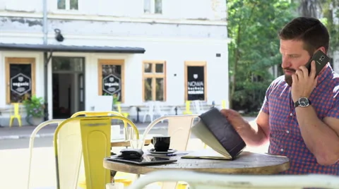 Man talking by smartphone makes notes to notebook, slider shot, right. Vídeo Stock 67629514