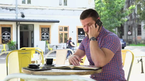 Man talking by smartphone makes notes to notebook Vidéo 67629948