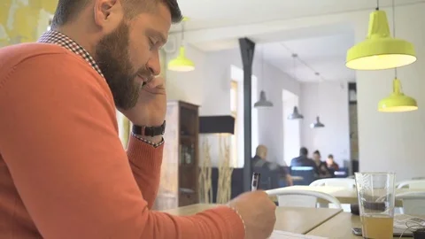 Man talking by smartphone, making notes in calendar, writing, close profile shot Vídeos de archivo 73292263