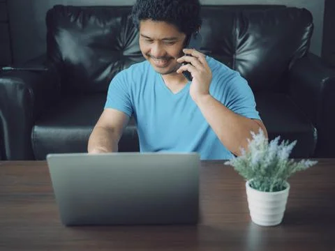 Man talking with smartphone. Man use Notebook labtop and Smartphone. Creative Stock Photos
