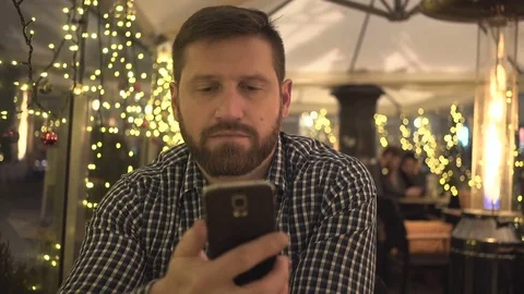 Man talking by smartphone, night, in cafe, steadicam shot, Christmas time St Vídeos de archivo 72782341