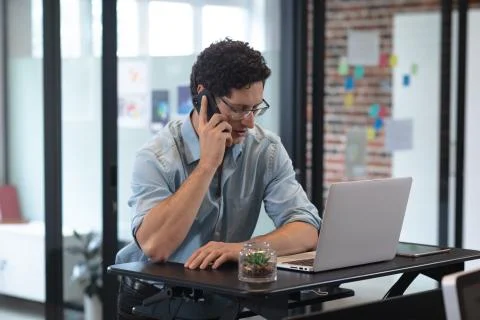 Man talking on smartphone at office Stock Photos