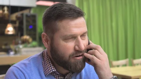 Man talking by smartphone, portrait, in pub, cafe, indoor, close steadicam shot Vídeo Stock 73067333
