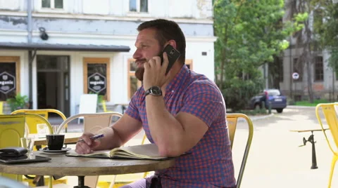 Man talking by smartphone smiles for camera, slider shot left 库存影片 67630025