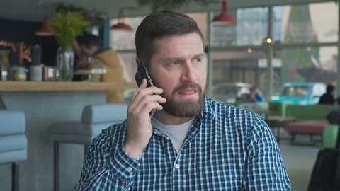 Man talking by smartphone, smiling at camera, cafe, portrait, steadycam shot Vidéo 72947010